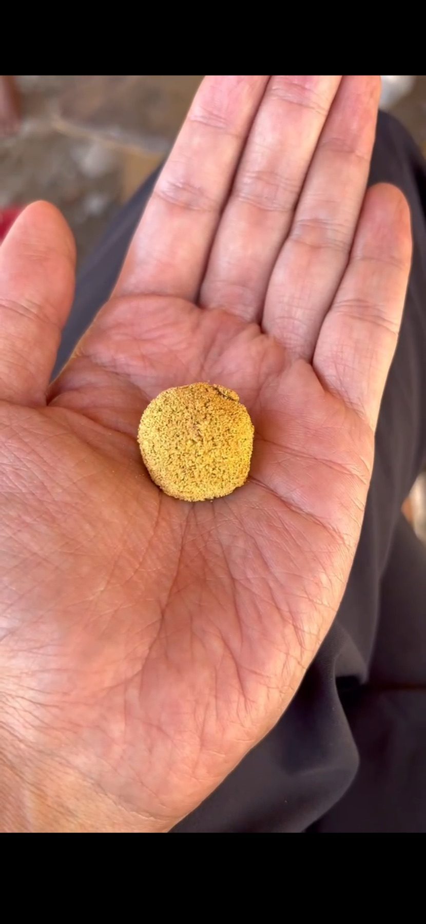 Recovered alluvial gold held in the palm of a hand
